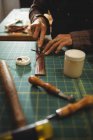 Mittelteil der Handwerkerin, die in der Werkstatt Leder schneidet — Stockfoto