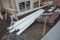 Tuyaux en plastique et planches de bois sur le chantier — Photo de stock