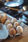 Close-up of eggs in egg carton on wooden table — Stock Photo