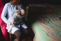 Mutter stillt Neugeborenes zu Hause im Schlafzimmer — Stockfoto
