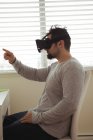 Вид сбоку человека, использующего гарнитуру виртуальной реальности, сидя за рабочим столом — стоковое фото