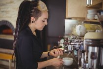 Kellnerin bereitet im Café eine Tasse Kaffee zu — Stockfoto