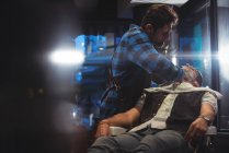 Männlich friseur rasieren client bart im barbershop — Stockfoto
