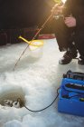 Середня секція льоду рибалка сидить на стільці в наметі з рибальським стрижнем — стокове фото