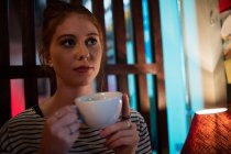 Donna premurosa che tiene una tazza di caffè nel bar — Foto stock