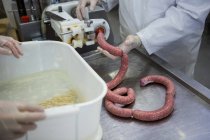 Milieu des bouchers transformant les saucisses en usine de viande — Photo de stock