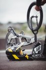 Cycliste réparant un vélo BMX dans un skatepark — Photo de stock