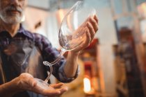 Close-up of glassblower holding a glassware at glassblowing factory — Stock Photo
