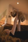 Fille couchée sur le canapé et jouer avec ours en peluche dans le salon à la maison — Photo de stock