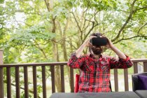 Молодий чоловік використовує гарнітуру віртуальної реальності на відкритій терасі — стокове фото