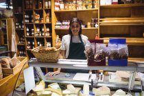 Female staff standing at cheese counter in supermarket — Stock Photo