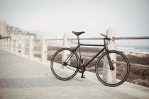 Vélo appuyé par une rampe de promenade près du bord de mer — Photo de stock