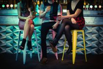 Freunde genießen alkoholische Getränke am Tresen in Bar — Stockfoto