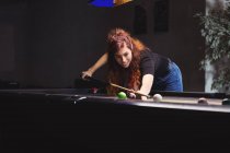Hermosa mujer jugando billar en el club de billar — Stock Photo
