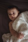 Cute baby lying on bed at home — Stock Photo