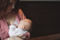Мати годує дитину грудьми в кафе, крупним планом — стокове фото