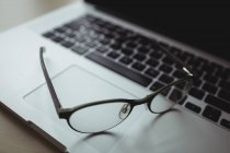 Close-up de óculos no laptop no escritório — Fotografia de Stock