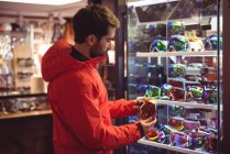 Man selecting ski goggles in a shop — Stock Photo