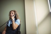 Бізнес-леді розмовляють на стаціонарній в офісі — стокове фото