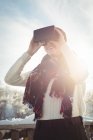 Крупный план женщины в зимней одежде с использованием VR гарнитуры — стоковое фото