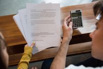 Coppia discutere con documenti finanziari e calcolatrice in soggiorno a casa — Foto stock