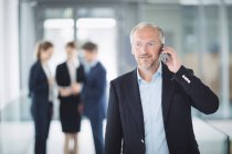 Впевнений бізнесмен розмовляє на мобільному телефоні в офісі — стокове фото