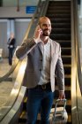 Бізнесмен розмовляє на мобільному телефоні в аеропорту — стокове фото