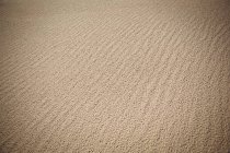 Primo piano della sabbia della spiaggia texture e increspature — Foto stock