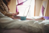Жінка використовує ноутбук на ліжку вдома — стокове фото