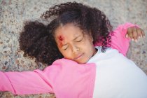 Close-up of unconscious girl fallen on ground after accident — Stock Photo