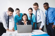 Team di medici che discutono su laptop in riunione nella sala conferenze — Foto stock