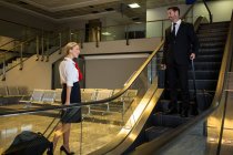 Авіаведуча взаємодіє з бізнесменом в терміналі аеропорту — стокове фото
