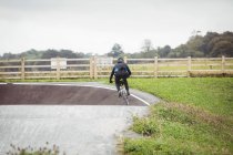 Rear view of cyclist riding BMX bike in skatepark — Stock Photo