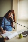 Donna d'affari incinta che parla al telefono mentre lavora in ufficio — Foto stock