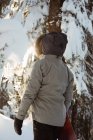 Femme debout et tenant un snowboard sur une montagne enneigée — Photo de stock