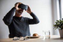 Людина використовує гарнітуру віртуальної реальності вдома — стокове фото