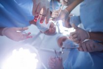 Grupo de cirujanos que realizan operaciones en quirófano del hospital - foto de stock