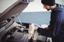 Hand of mechanic servicing car with a tool at repair garage — Stock Photo