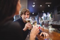Pareja tomando bebidas juntos en el bar - foto de stock