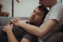 Romantico gay coppia rilassante su divano in soggiorno a casa — Foto stock