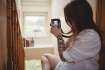 Woman taking photo on digital camera at home — Stock Photo