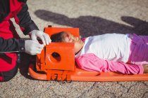 Menina ferida tratada por paramédico no local do acidente — Fotografia de Stock