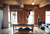 Treinador aconselhando mulher enquanto pratica pilates no estúdio de fitness — Fotografia de Stock