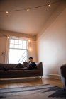 Mann telefoniert zu Hause im Wohnzimmer — Stockfoto