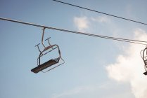 Elevador de esqui vazio na estância de esqui contra o céu azul — Fotografia de Stock