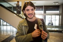 Щасливий чоловік тримає в кишені паспорт в терміналі аеропорту — стокове фото