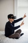 Человек использует гарнитуру виртуальной реальности в спальне дома — стоковое фото