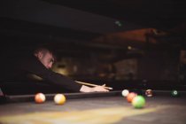 Young man playing pool playing pool in the billiards club — Stock Photo