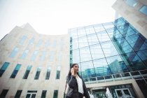 Woman talking on mobile phone outside the office premises — Stock Photo