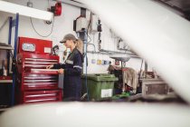 Mechanikerin sortiert Werkzeuge in Werkzeugkasten in Reparaturwerkstatt — Stockfoto